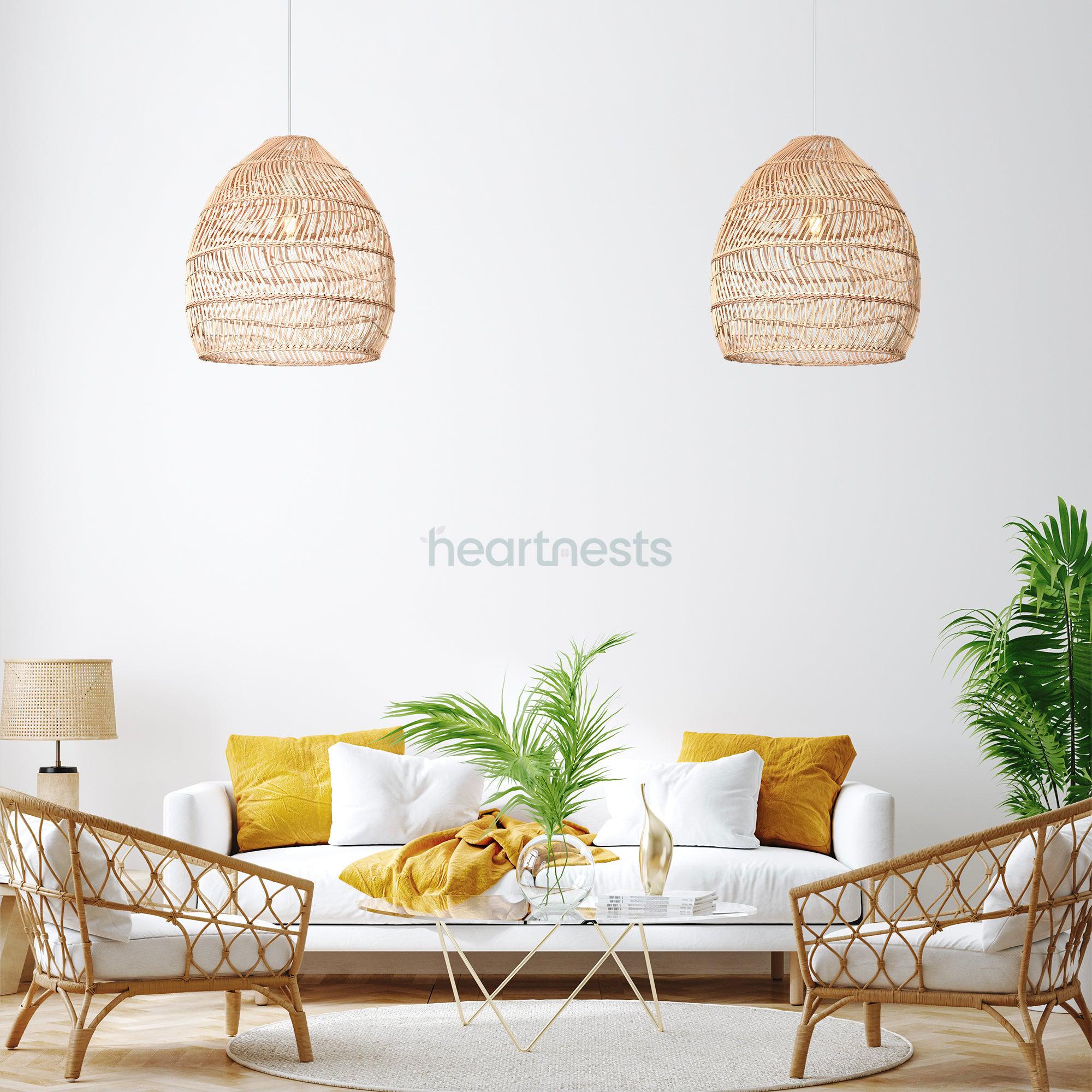 2 of Heart Nests's Acacia rattan pendant light are hung side by side in a short distance from each other, above a white round table, a white sofa and 2 rattan chairs