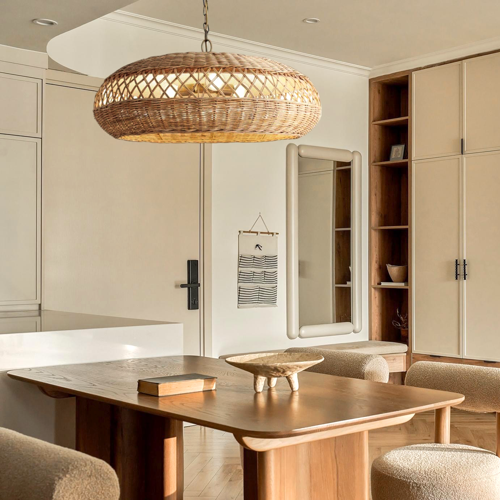 The Almafi rattan hanging light is hung above a minimalistic dining wooden table