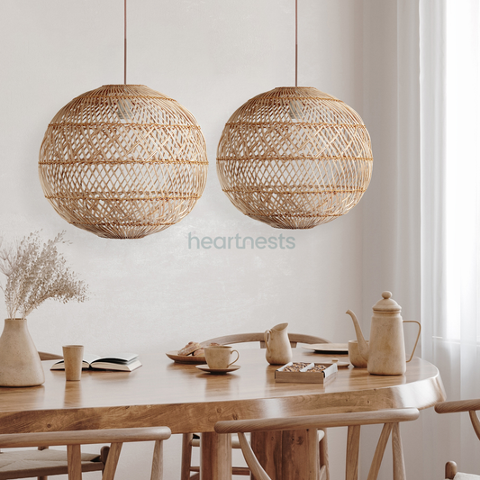 2 Ballia round shape rattan pendant lights are hung above a dining wooden table in boho style