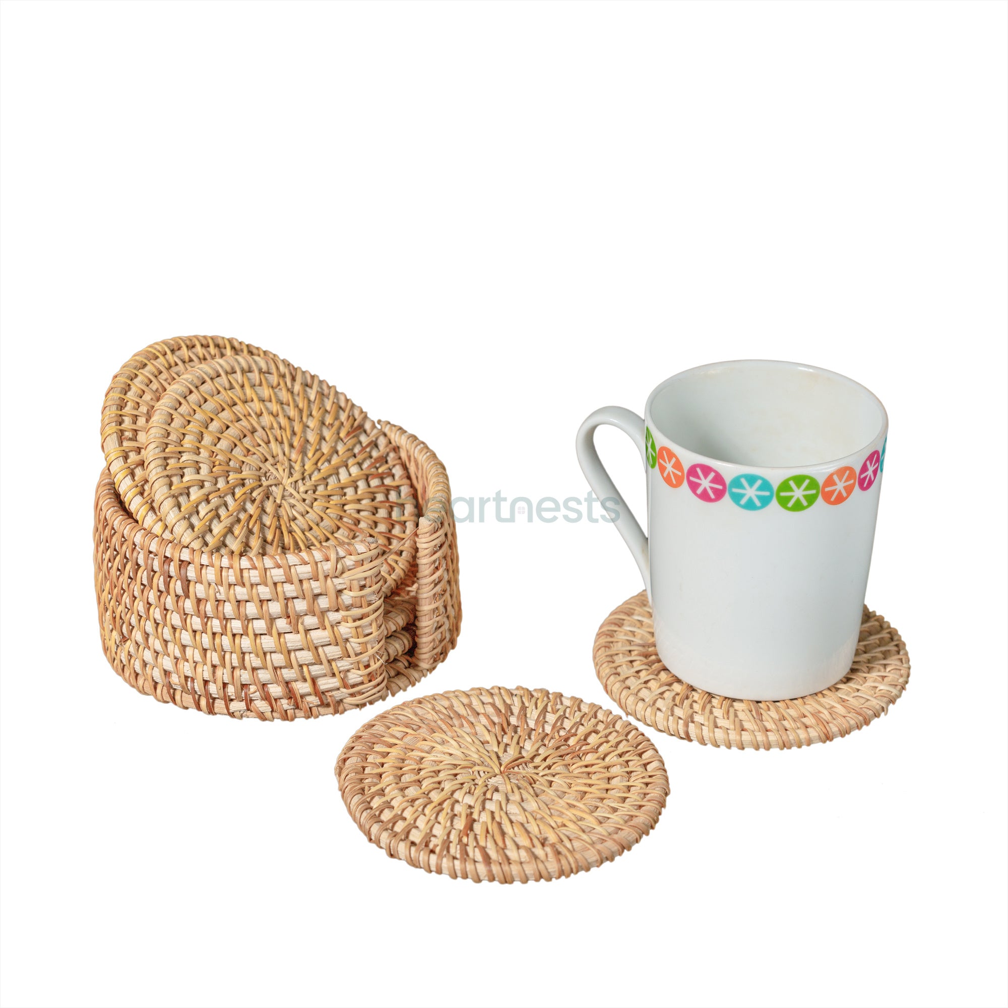 An arrangement of a white glass placed on a Heartnests's Costella Rattan Coaster next to a coaster holder