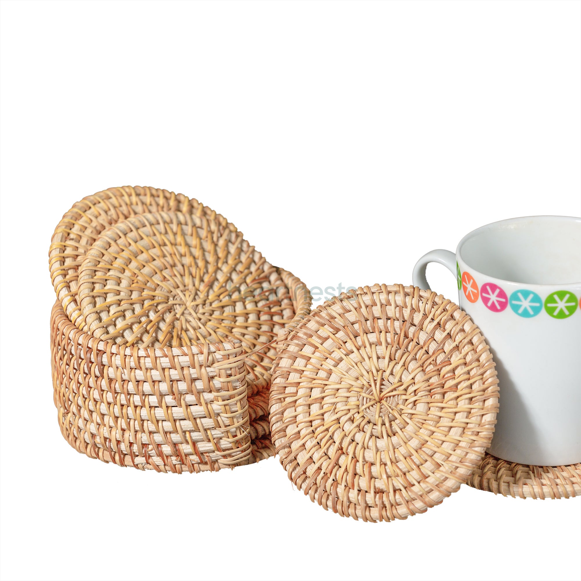 An arrangement of a white glass placed on a Heartnests's Costella Rattan Coaster next to a coaster holder