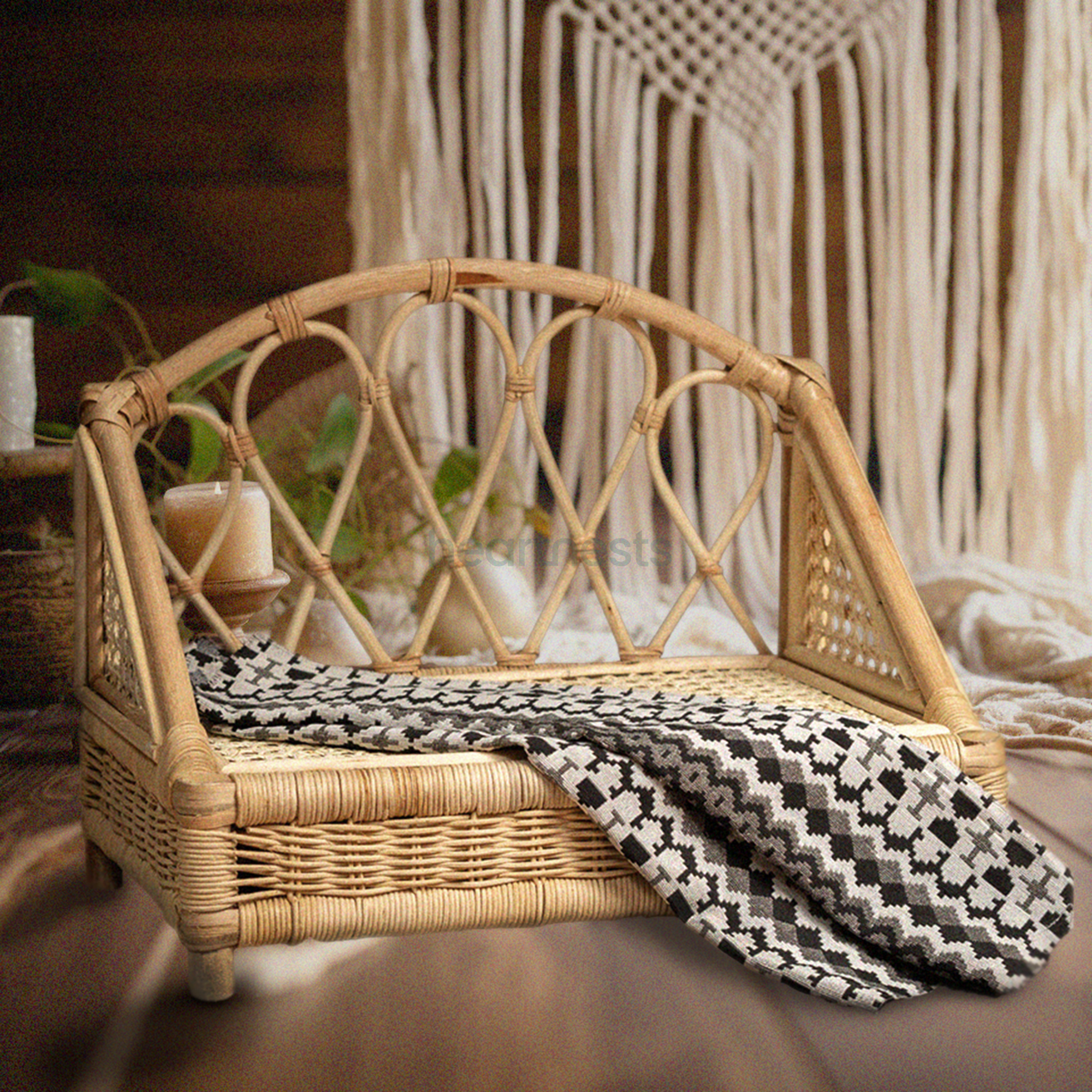 A Heartnests's Crown Rattan Newborn Prop is on a wooden floor and in front of a white macrame tassles
