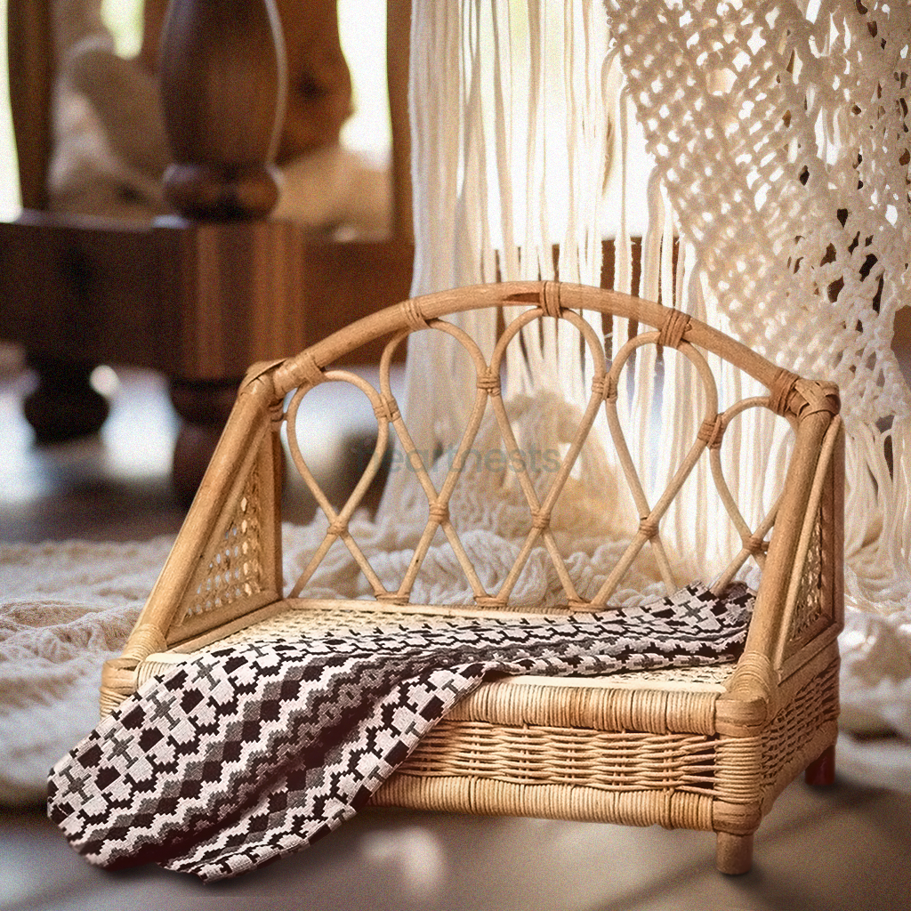 A Heartnests's Crown Rattan Newborn Prop is on a wooden floor and in front of a white macrame tassles