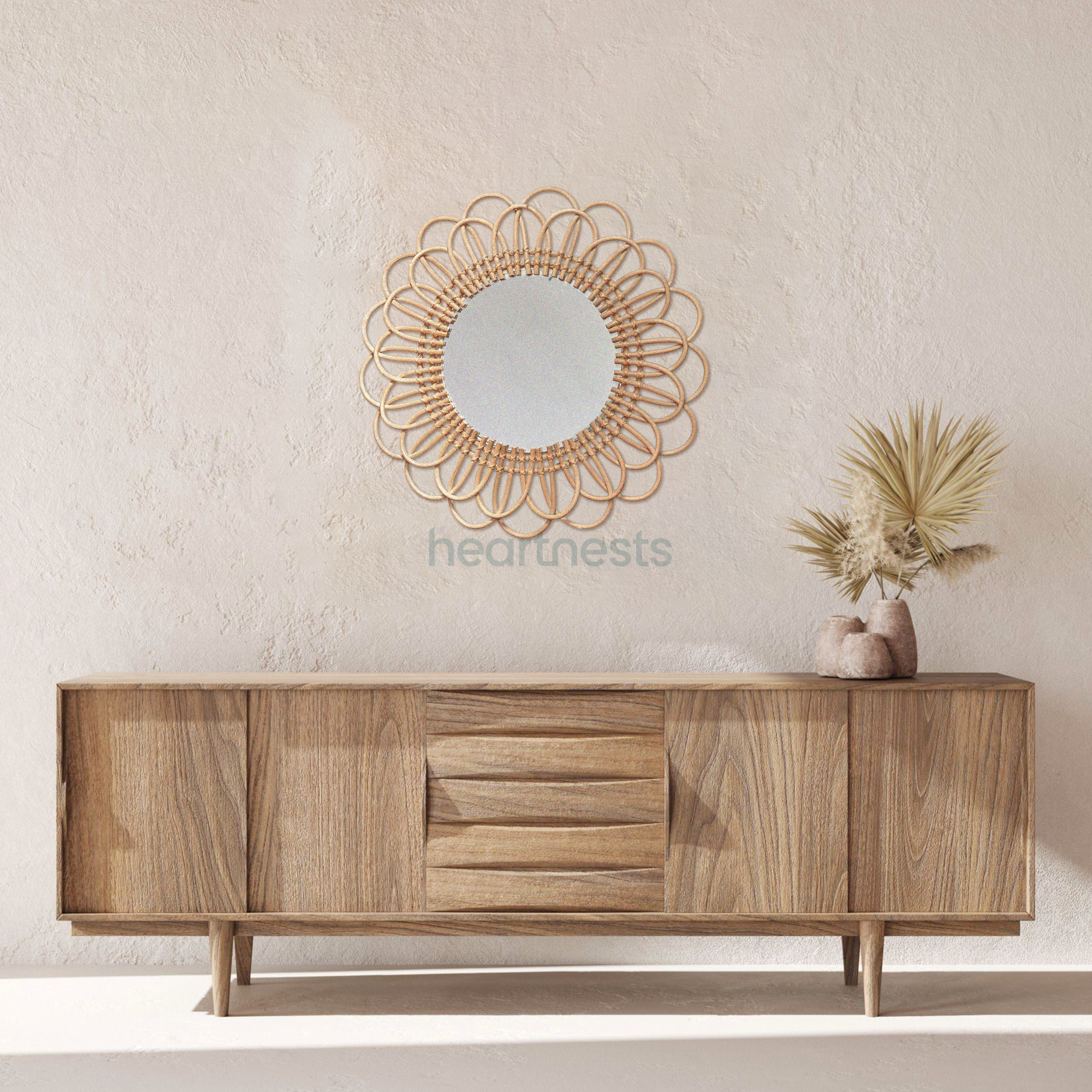 A Heartnests' Flora Rattan Mirror is hung on a pink wash wall above a hall way wooden table