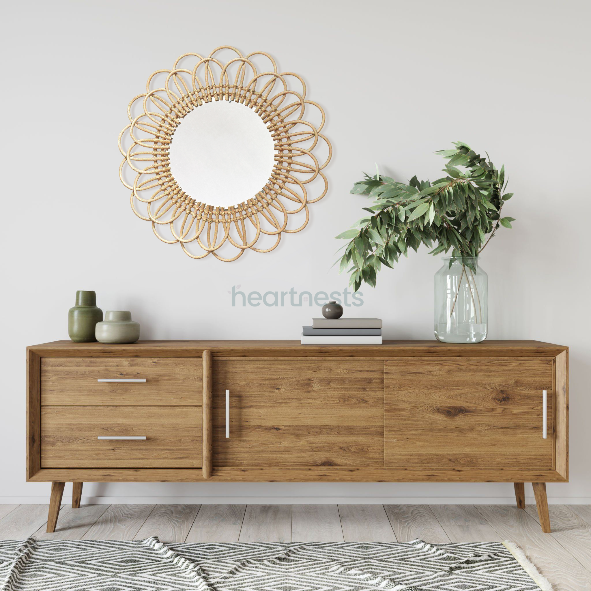 A Heartnests' Flora Rattan Mirror is hung on a white wall above a hall way wooden table