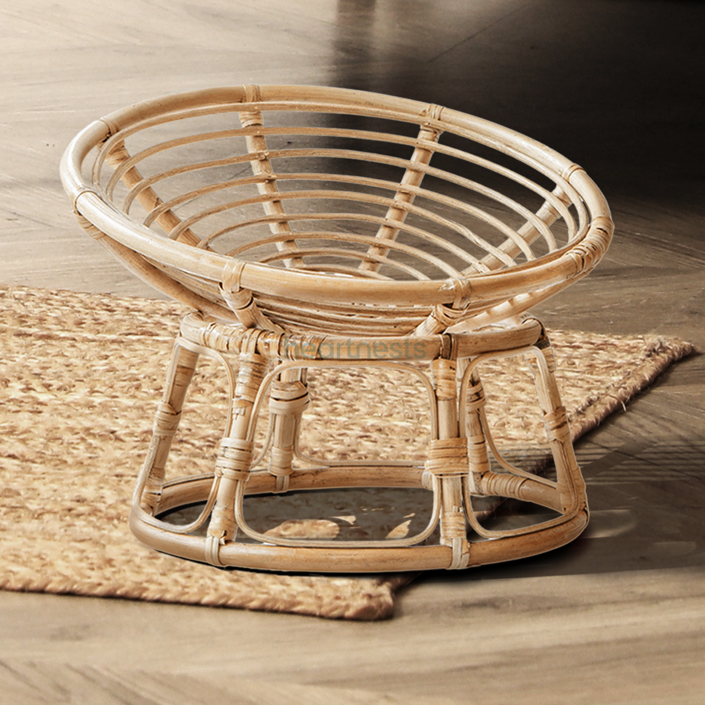 A Heartnests' Molisa Rattan Baby Parpasan Chair for Newborn Photography is on a jute rug of a nursery