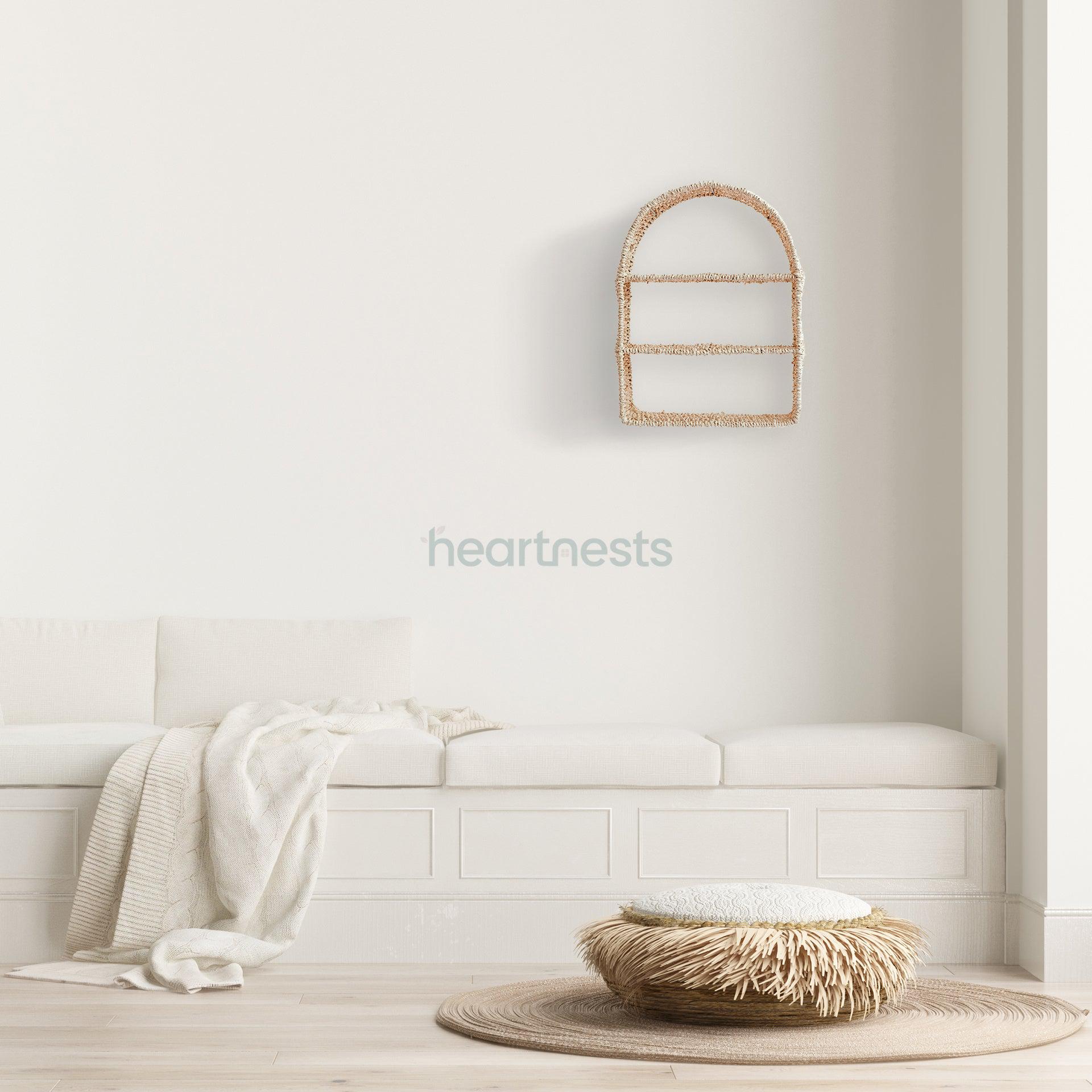 Heartnests' Raina Water Hyacinth Wall Organiser is hung above a white lounge and a seagrass cushion