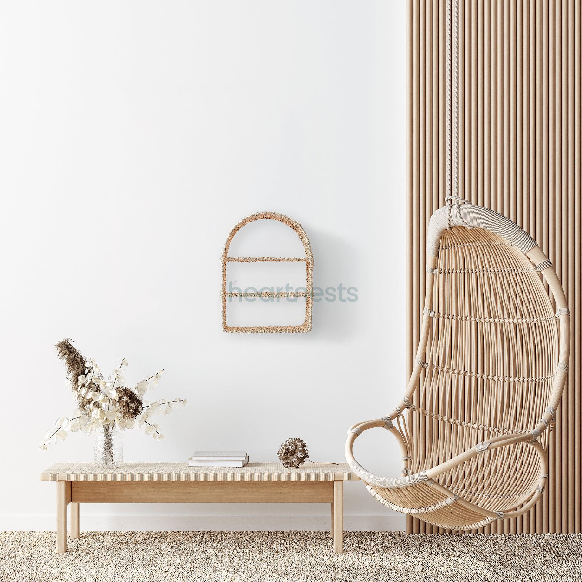 Heartnests' Raina Water Hyacinth Wall Organiser is hung above a wooden bench and next to a rattan swing