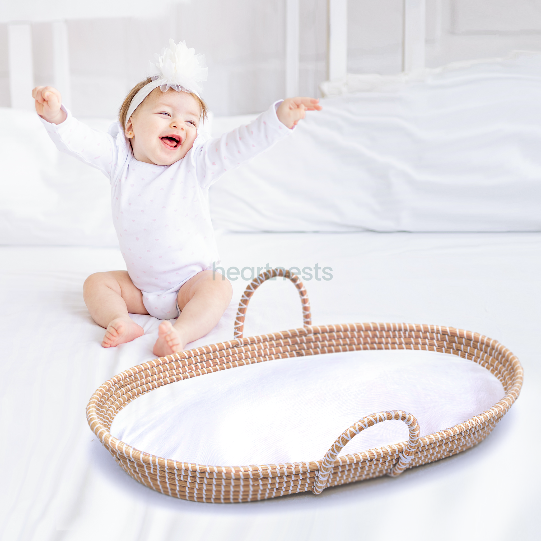 A close view of Heartnests's Bubish Baby Changing Basket with a white foam mattress and a happy baby sitting next to it