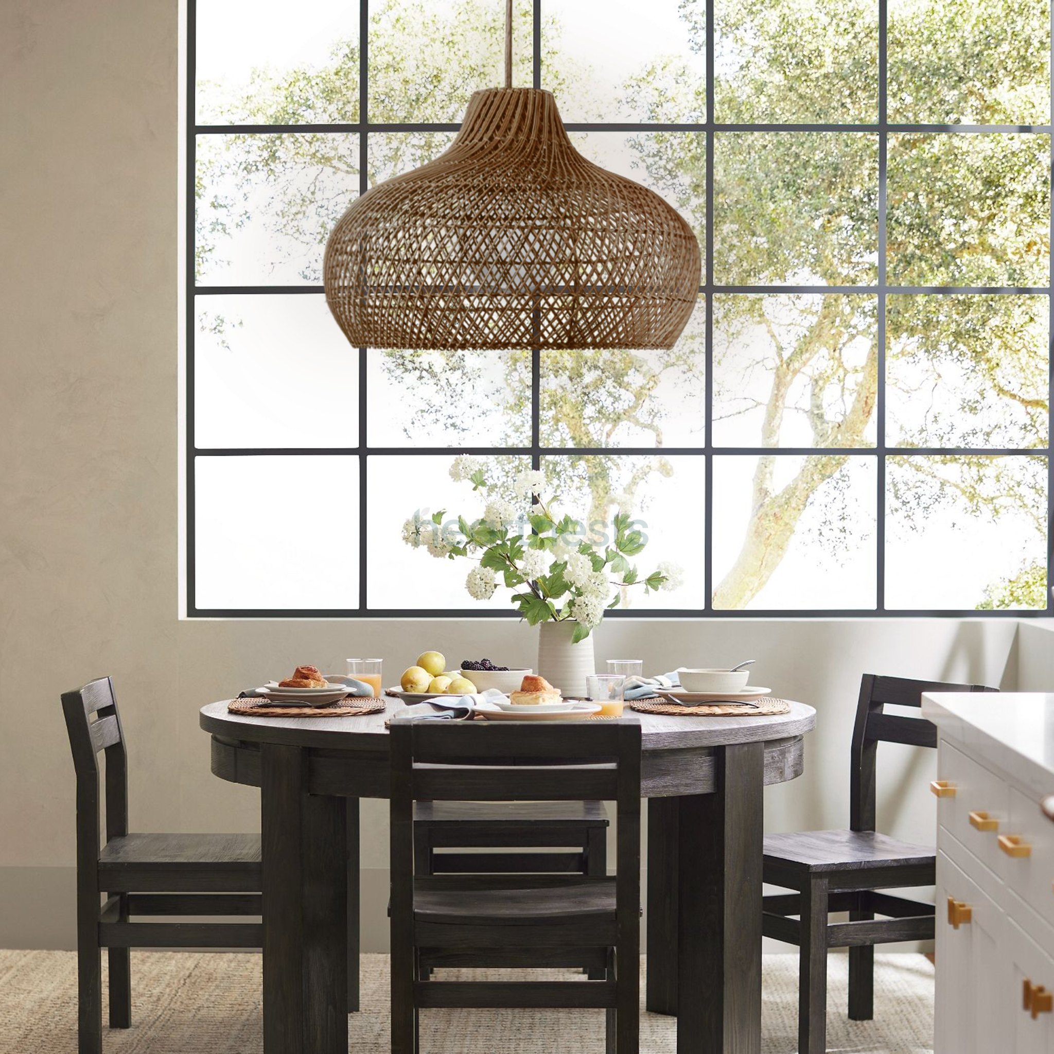 A Heartnests's Fraser Wicker Pendant Light is hung above a set of dark color wooden living room, next to a large window with a lot of sunshine