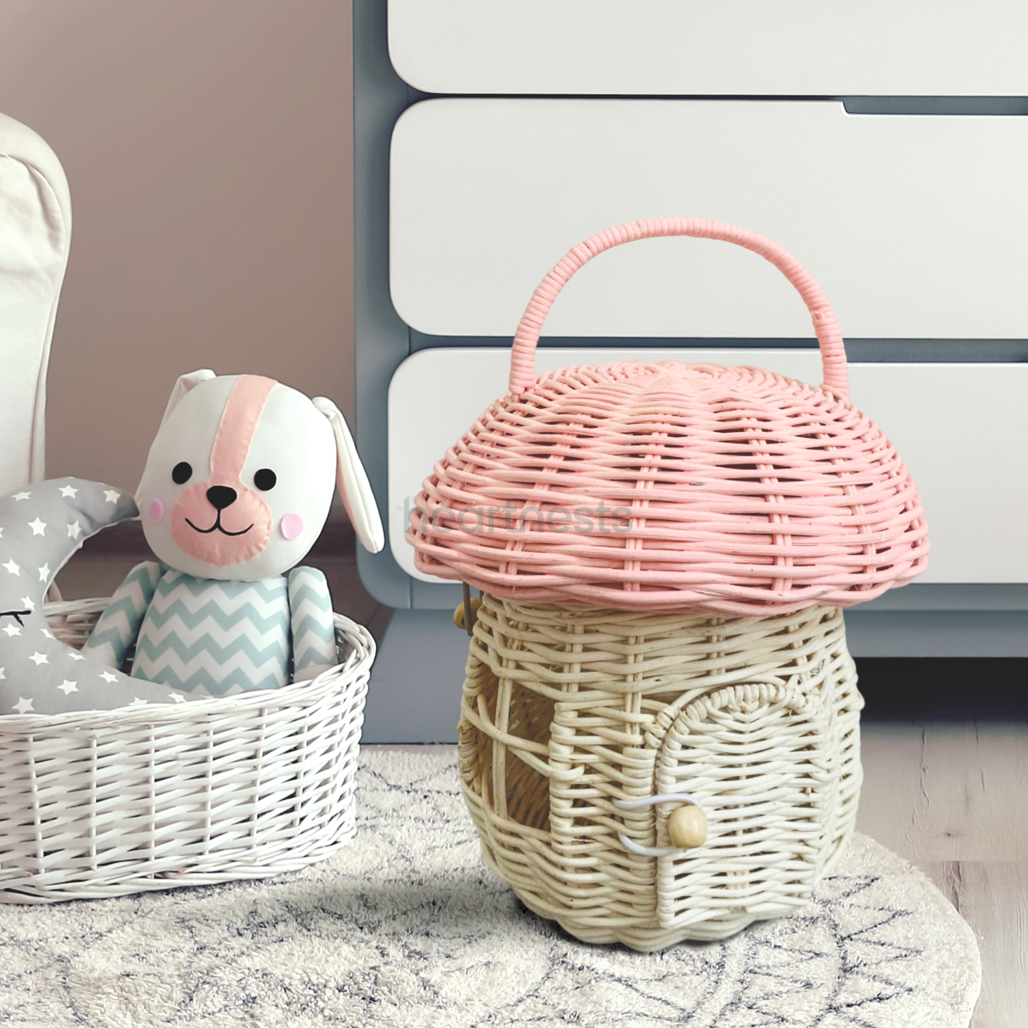 Heartnests' Pinky Rattan Mushroom is on a white rug next to a basket of teddy bear in a nursery