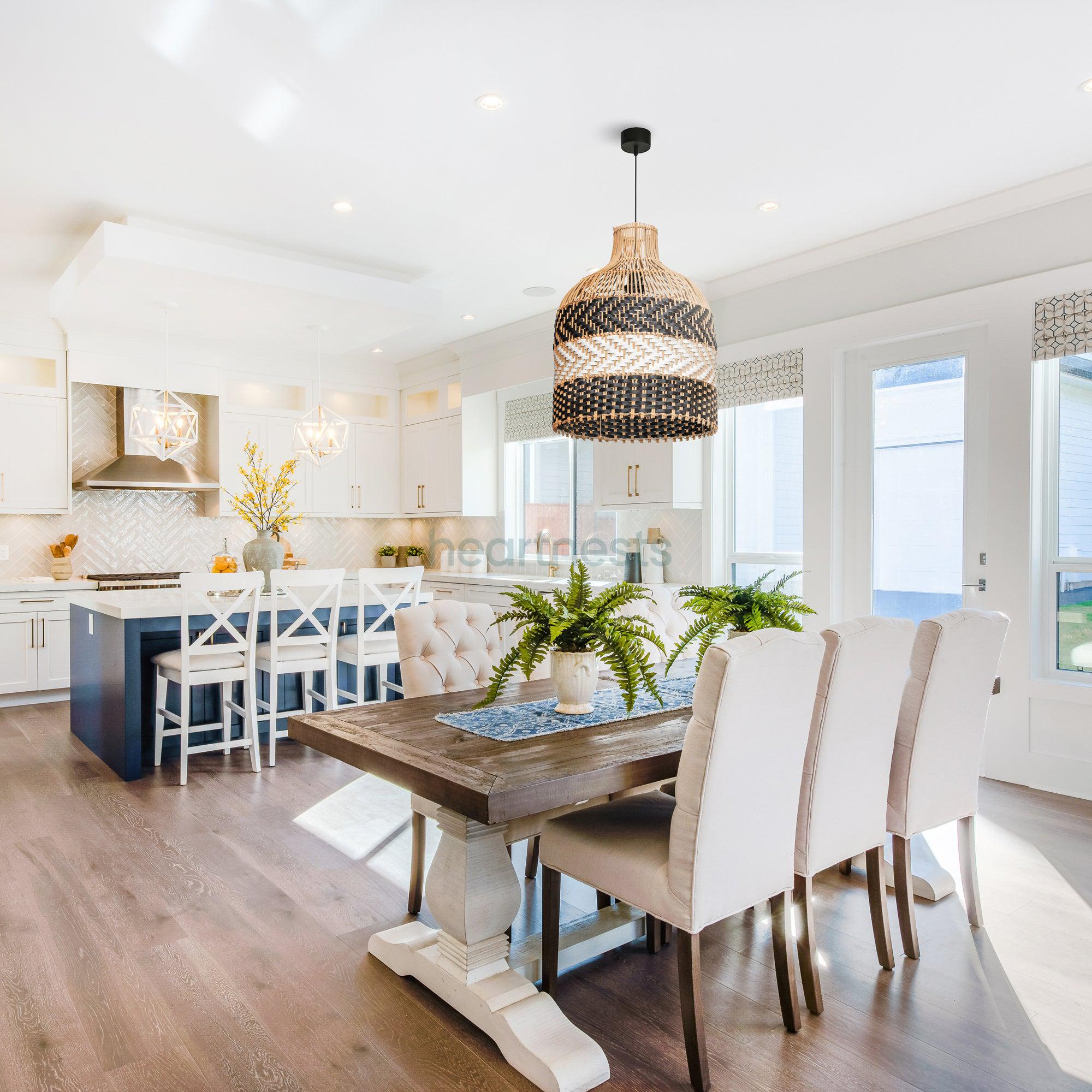 A Heartnests' Luka Rattan Pendant Light is hung above a rectangular dining table with 6 light grey dining chairs in a contemporary bright living room with blue hue kitchen island