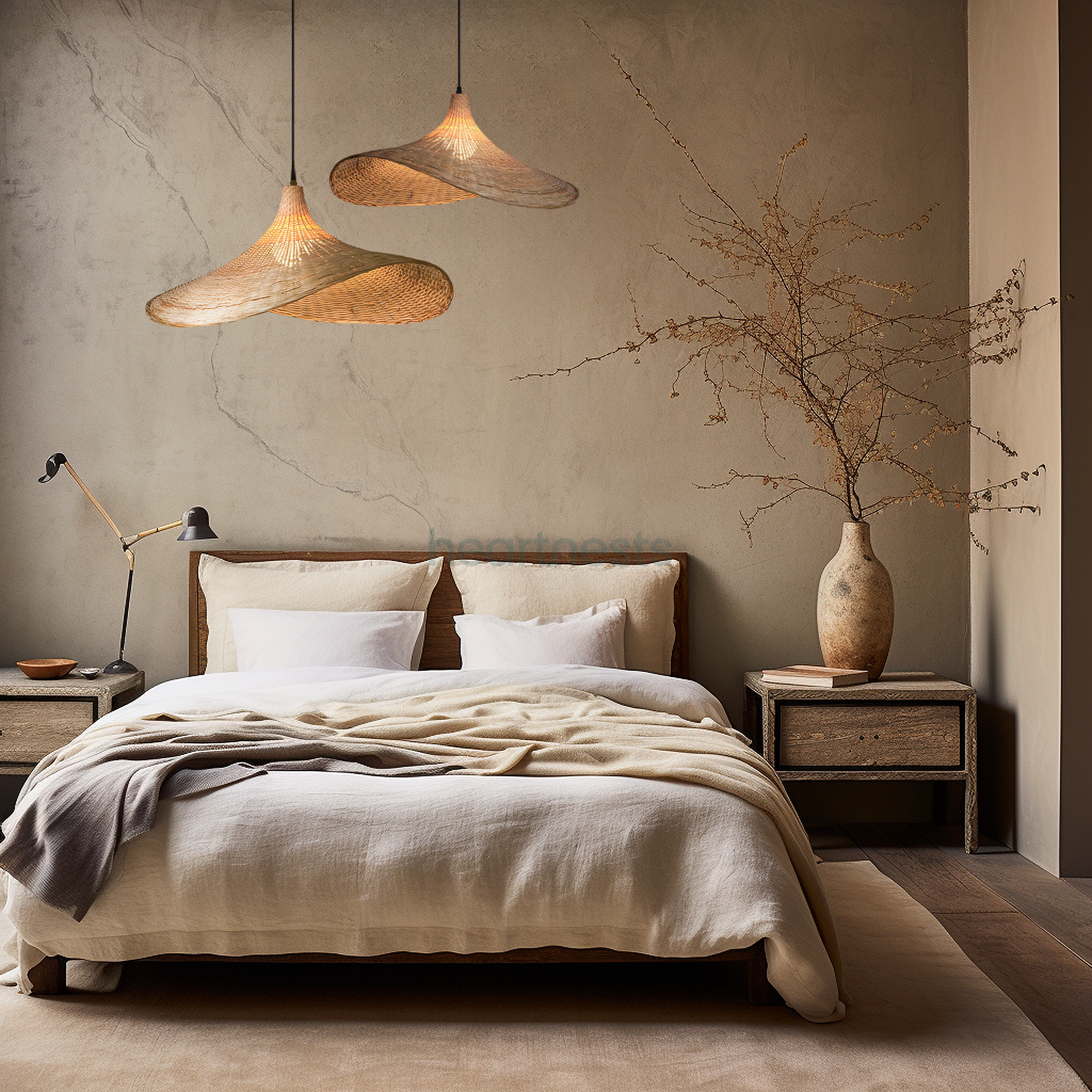 2 of Heartnests' Mexica Wicker Hanging Lights are hung at different heights above a bed with light grey color quilt cover and there's a terra cotta flower vase with flower branches on a bedside table on the right handside of the bed