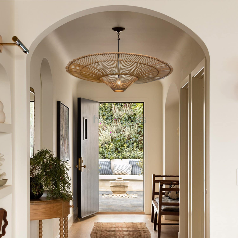 A Heartnests' Orbita Rattan Pendant Light is hung in a hallway with arch wall