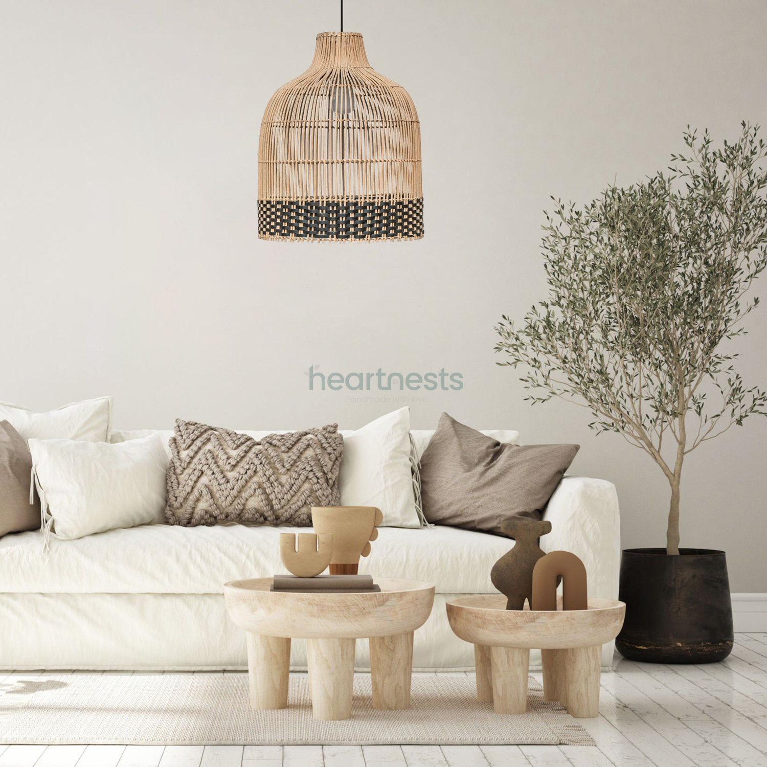 Heartnests's Ayla rattan hanging light is hung above a small wooden living room table and a white cloud chase sofa standing next to a pot plant