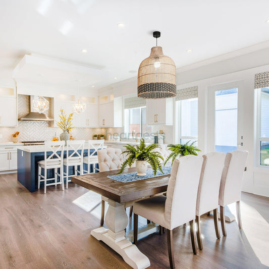 Heartnests's Ayla rattan hanging light is hung above a dining table with 6 dining chairs in a large living room with 3 window and wooden floor, inspired by contemporary decor style