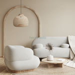 A Bali bamboo pendant light is hung above a beige colour sofa and a living room table following modern organic design