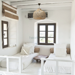 A Bali bamboo lampshade from Heart Nests is hung above 2 single beds in coastal style room decor