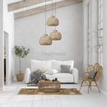 3 Bali bamboo pendant lights from brand Heart Nestsare hung in different heights above a wooden natural tone living room table and a light gray cloud chase sofa following coastal rustic style