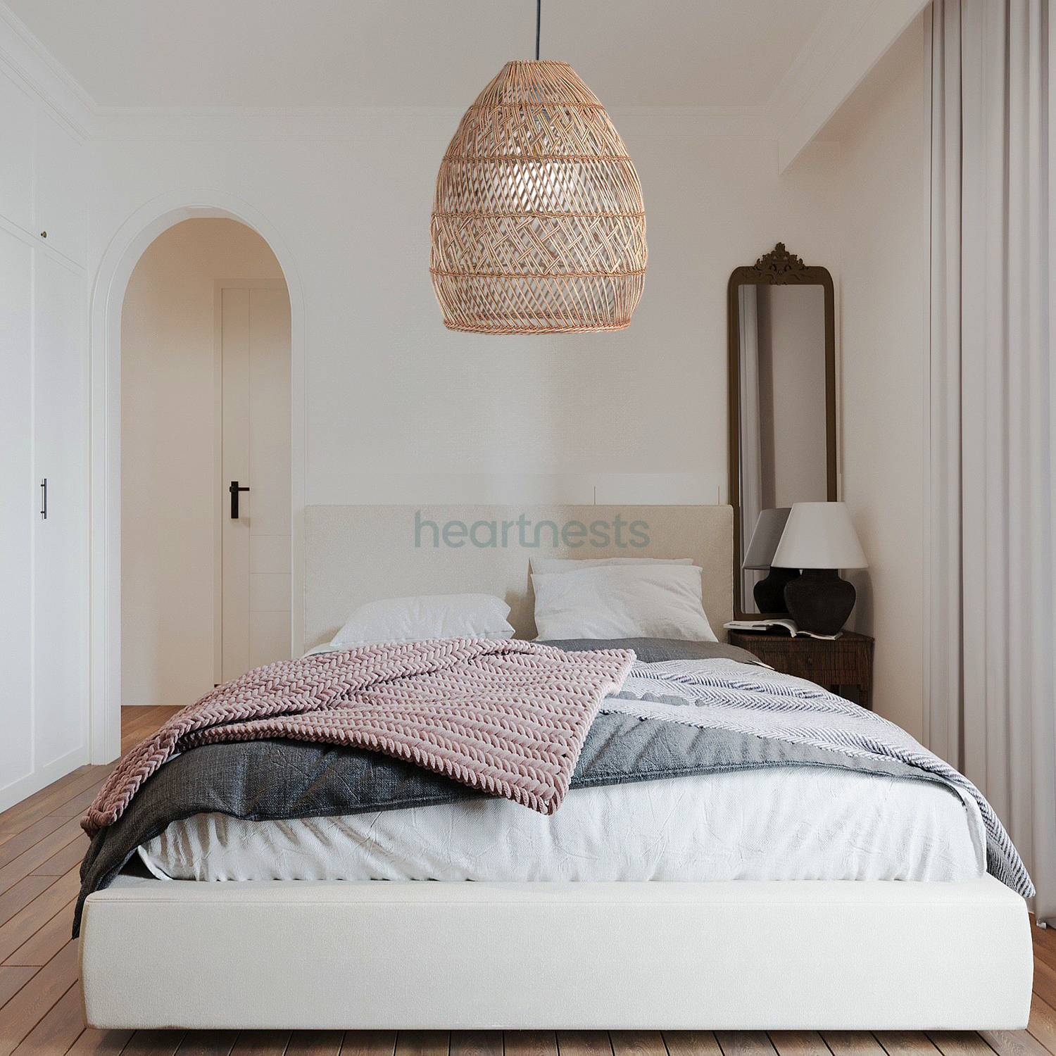 A Brighton rattan pendant light is hung from the ceiling of a modern scandinavian style bedroom, above a white colour bed