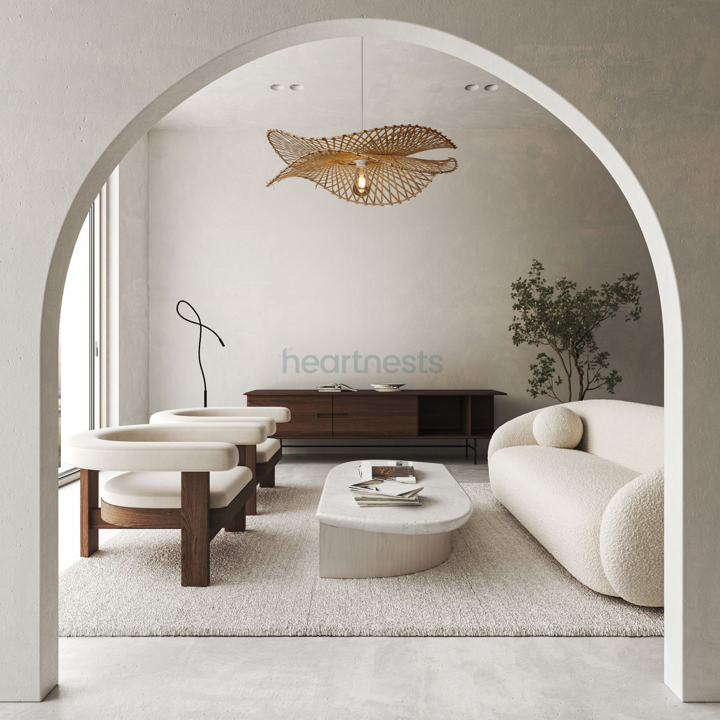 A Heartnests's Correa Bamboo Pendant Light is hung above a white stone living room table and a bouncle couch