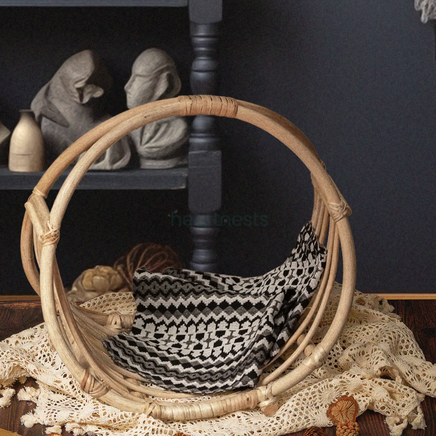 A Heartnests's Wicker Newborn Photography Prop is placed on a white macrame next to a beautiful white flower vase