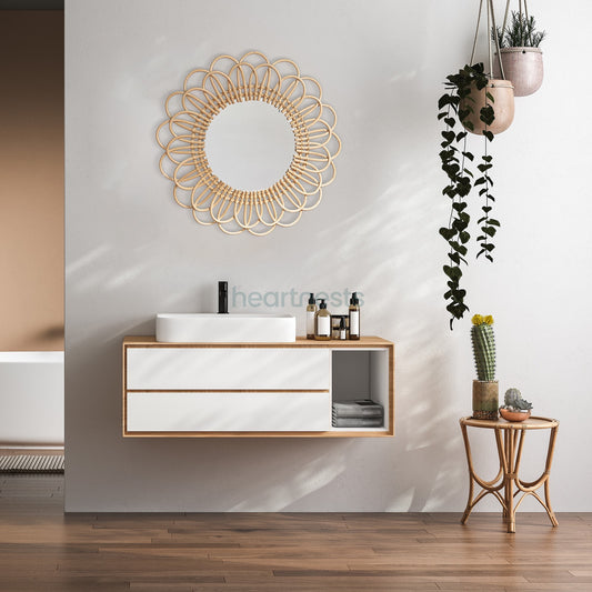 A Heartnests' Flora Rattan Mirror is hung on a white wall above a small size table