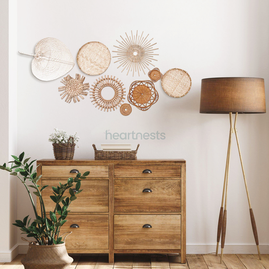 A set of Heartnests' 9 Freiya rattan and seagrass wall decor are hung above a brown wooden tall chest which is next to a same color tone floor lamp, following bohemian home decor style