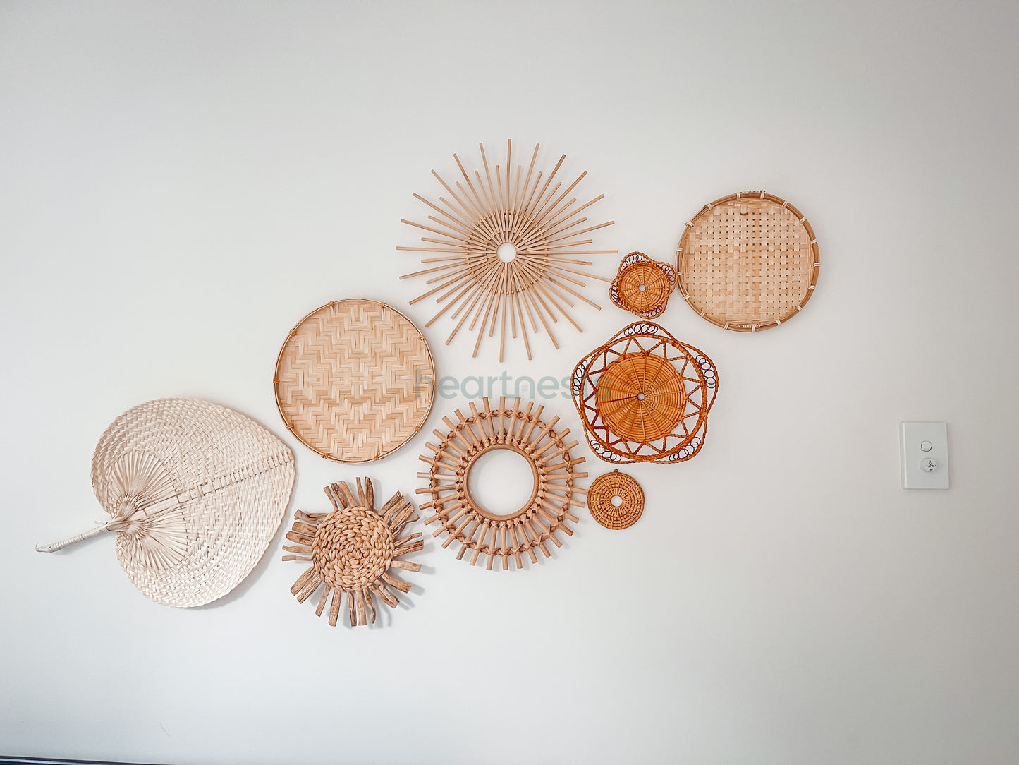 A set of Heartnests' 9 Freiya rattan and seagrass wall decor are on a white wall