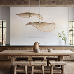 2 of Heartnests' Hakea Bamboo Hanging Lights are hung above a wooden dining table and 3 wooden dining chairs in a wabi sabi decor style dining room