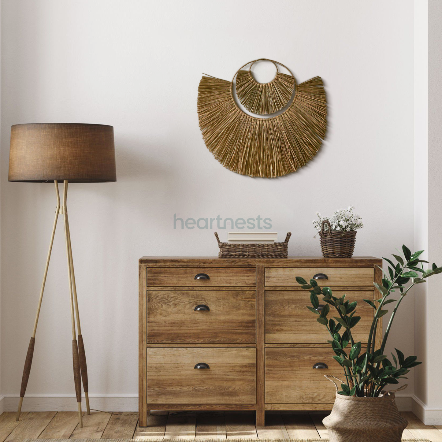 Heartnests' Moon Seagrass Wall Decor in size Large and Small are hung above a wooden neutral tone tall chest table next to a neutral color wood floor lamp