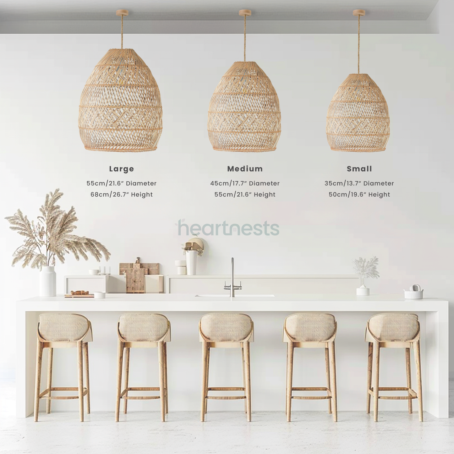 3 of Heartnests' Brighton Wicker Hanging Lights in 3 different sizes are hung side by side over a wooden kitchen island with white marble top