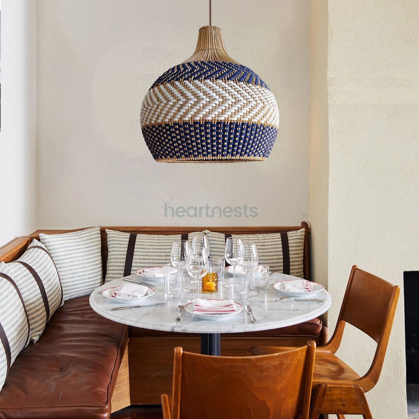 A Heartnests' Cosmo rattan pendant light is hung above a dining table with wooden chairs in minimalistic style