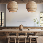 2 Illia Bamboo pendant light are hung above a wooden rustic dining table