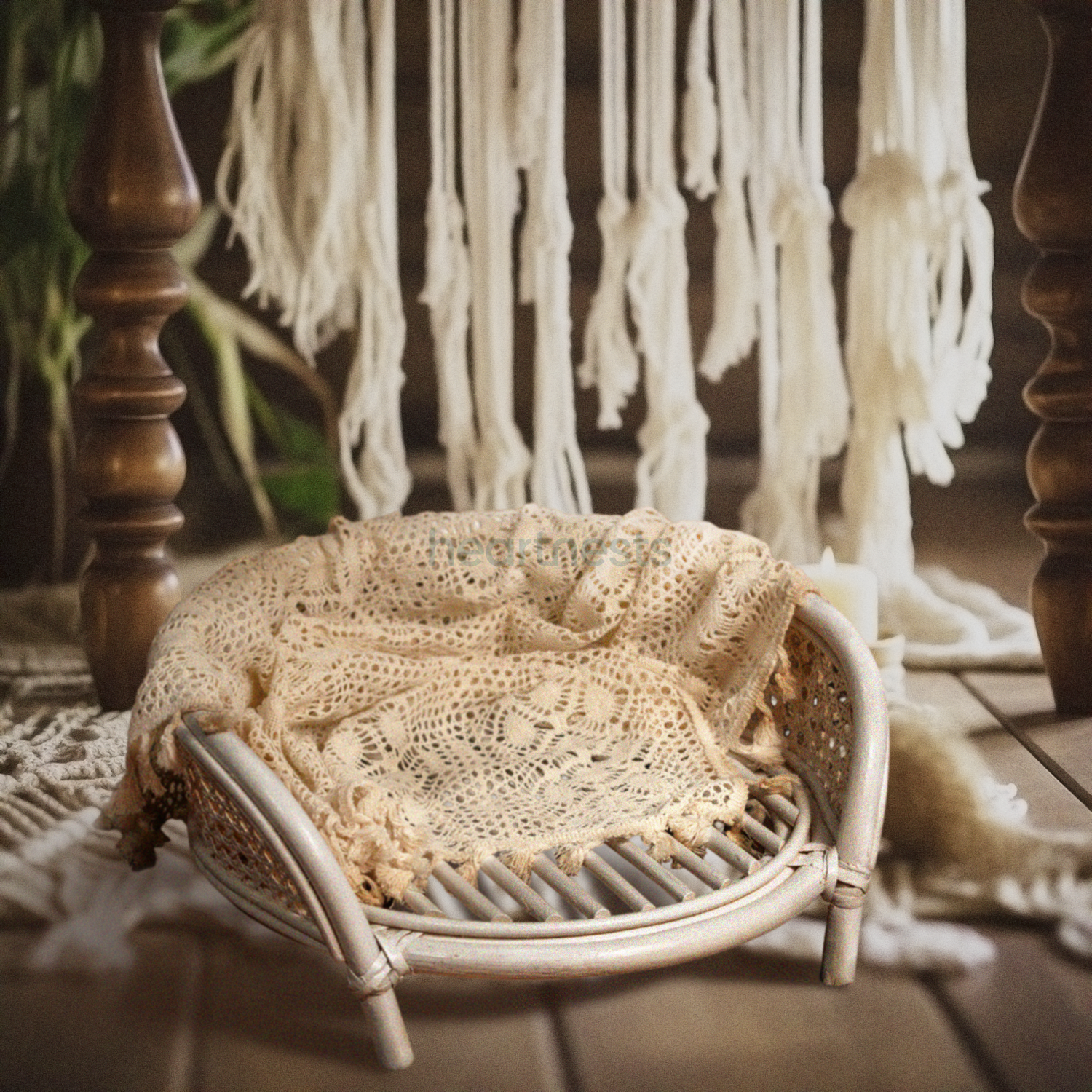 A Heartnests' Lilly Rattan Baby Prop in cream colour is placed on dark wooden flooring and in front of a white macrame hung down from the wall