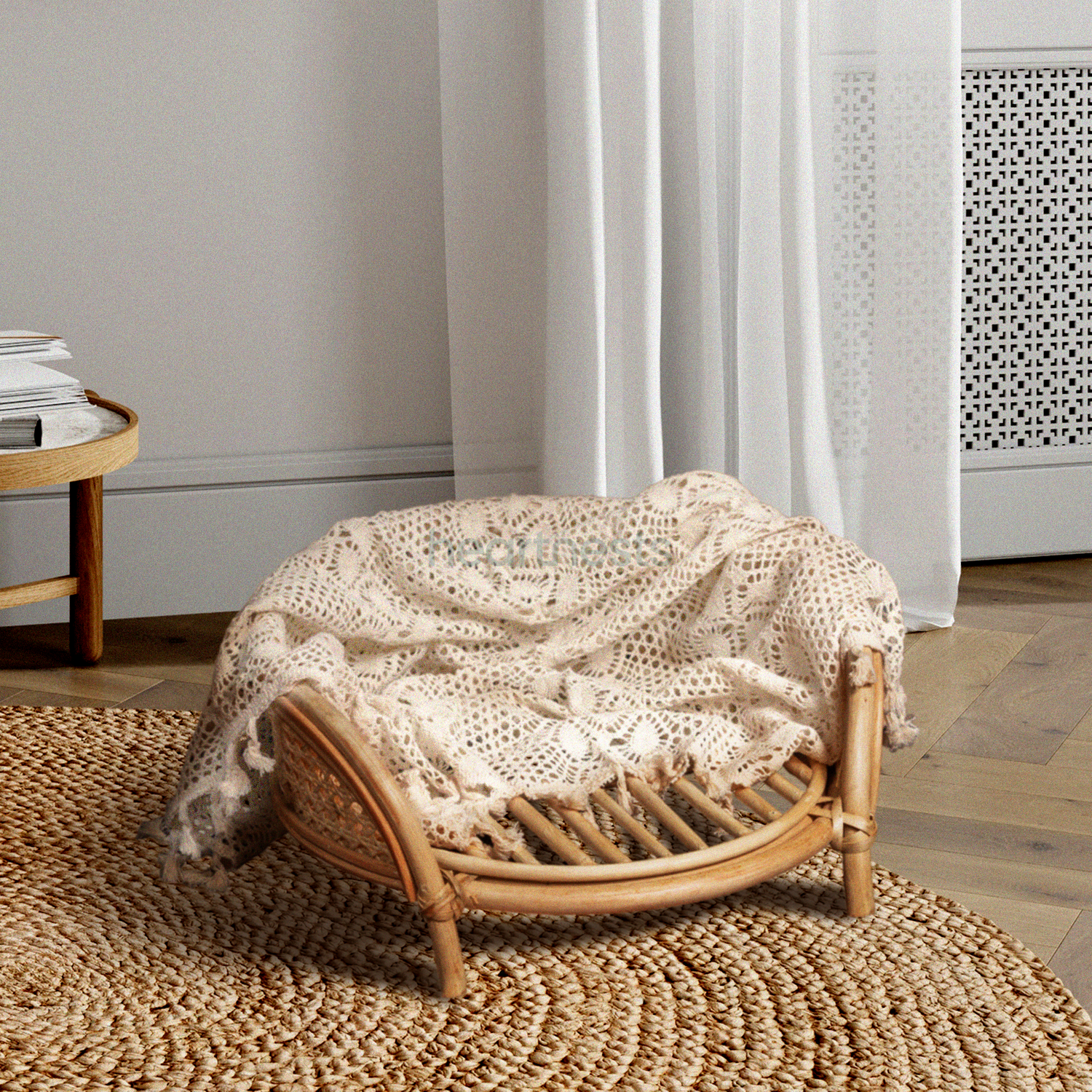 A Heartnests' Lilly Rattan Baby Prop in natural rattan colour is on light brown wooden flooring placed in front of a white curtain and light grey wall