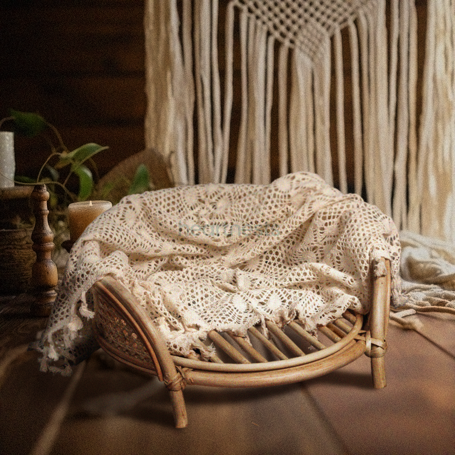 A Heartnests' Lilly Rattan Newborn Prop in natural rattan colour is on dark brown wooden floor placed in front of a large cream colour macrame