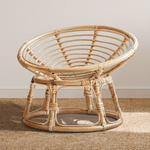 A Heartnests' Molisa Rattan Baby Parpasan Chair for Newborn Photography is on a wooden floor