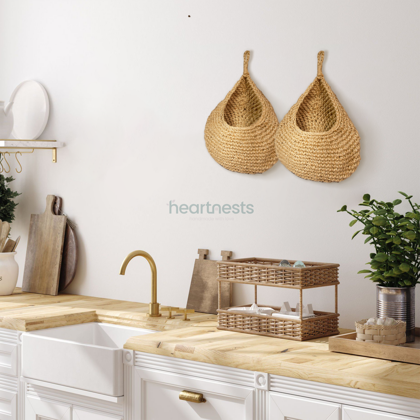 2 of Heartnests' Onia Seagrass Wall Storage are hung side by side above a wooden top kitchen island with a wooden chopping board and mini pot plant