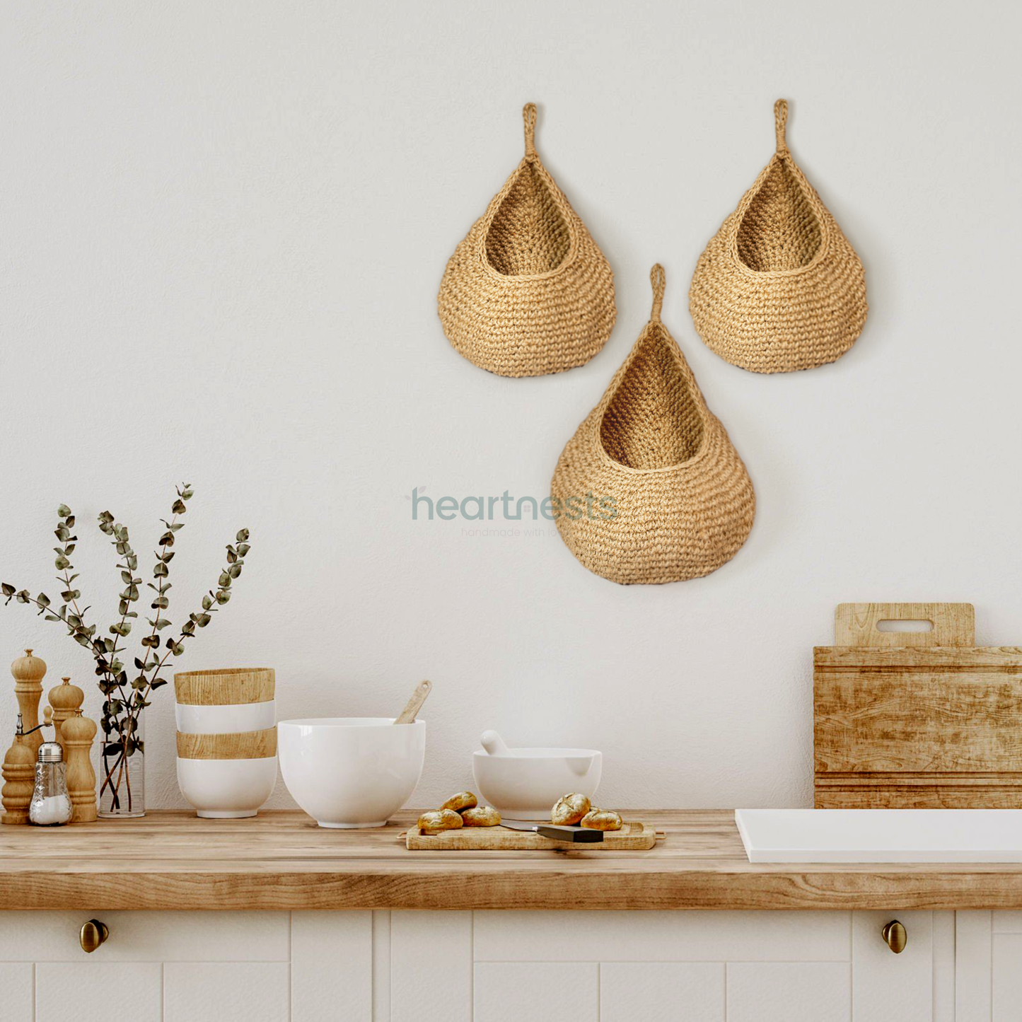 3 of Heartnests' Onia Seagrass Wall Baskets are hung at different heights above a wooden kitchen island