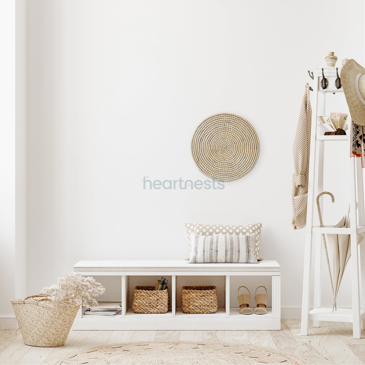 Heartnests' Ricey Wicker Wall Decor is hung on a white wall above a white shoes storage placed next to a white clothes rack and a seagrass bag holding flowers 