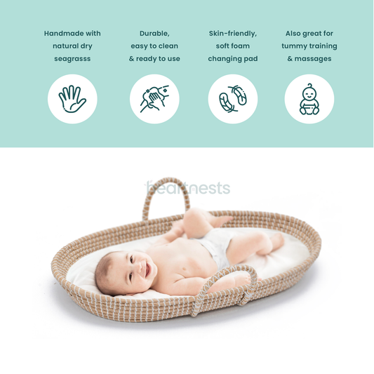 A close up view of Heartnests's Bubish Seagrass Changing Basket with a white foam mattresswith a happy baby laying inside. The picture also lists all functions and benefits of the product