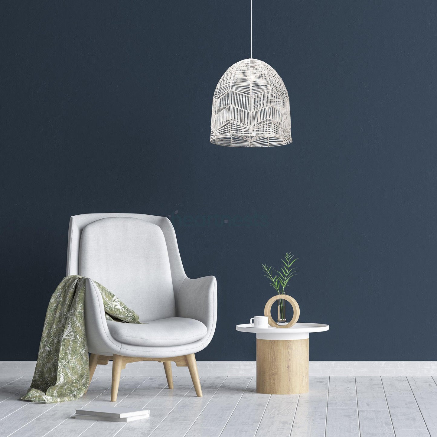 Whitewash Lacy rattan lace pendant light is hung above a small wood stool and a sofa. The room is painted dark blue