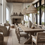 2 of Heartnests' Lombok Jute Wicker Lampshades are hung above a rectangular wooden dining table with 10 wooden chairs in a coastal farmhouse style kitchen opened up to a living room