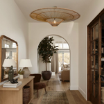 A Heartnests' Orbita Rattan Lampshade is hung in a bedroom above a makeup table