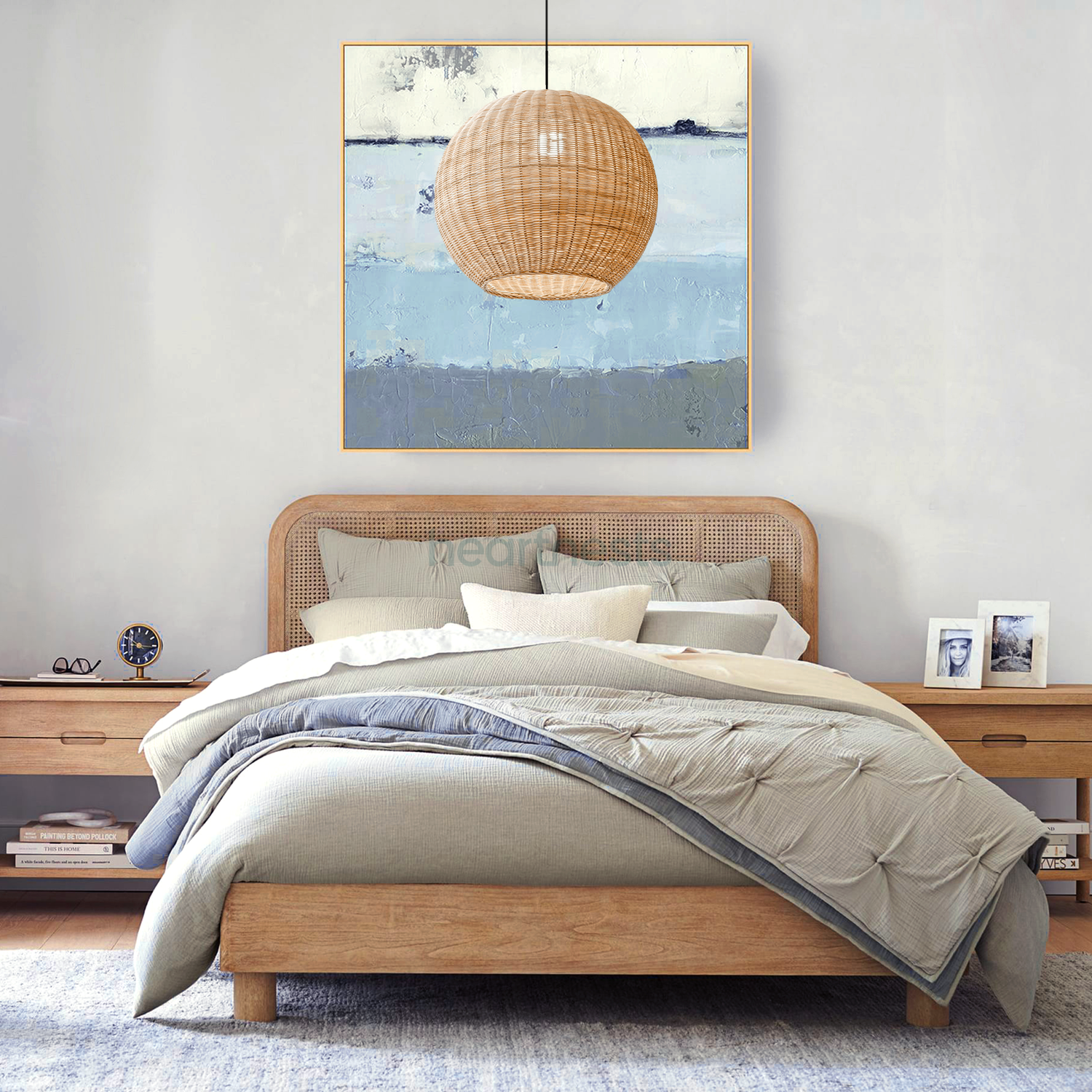 1 of Heartnests' Preethy Round Pendant Light is hung above a wooden bed and in front of an ocean painting