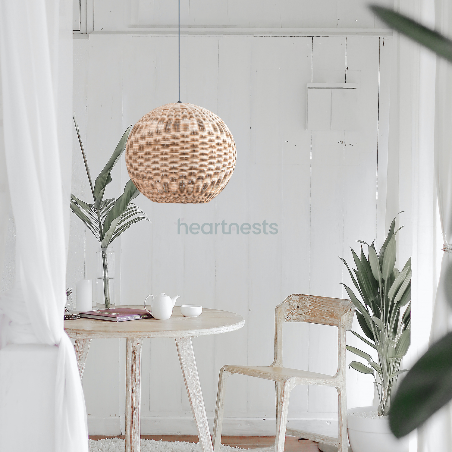 1 of Heartnests' Preethy Wicker Round Pendant Light is hung above a small round table and a matching chair